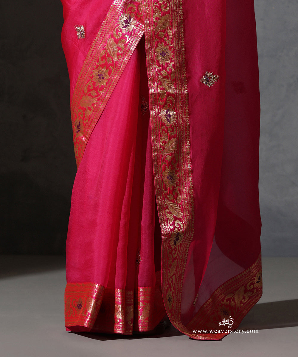 Close-up of Vasundhara hot pink organza saree showing hand-embroidered zardozi bootis and the intricate vintage Banarasi meenakari border.