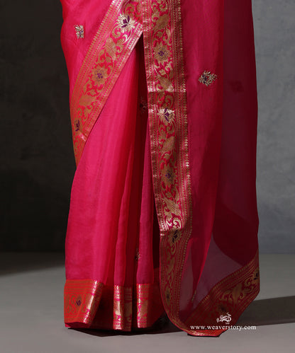 Close-up of Vasundhara hot pink organza saree showing hand-embroidered zardozi bootis and the intricate vintage Banarasi meenakari border.