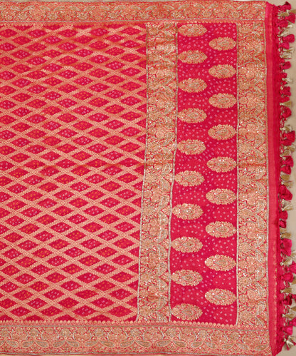 Full view of hot pink Banarasi Bandhani dupatta with a zari lattice body, broad paisley palla, zardozi highlights and tasselled edging.