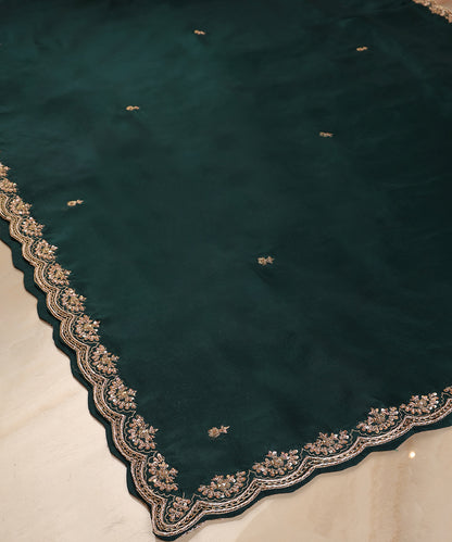 Close-up of dark bottle green handloom organza dupatta with delicate zardozi bootis and an ornate floral scalloped border.