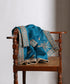 Firozi blue Luxury Edit organza dupatta draped over a wooden chair, showcasing intricate metallic zardozi embroidery and ornate floral borders.
