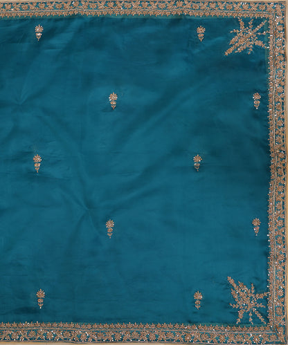 Full view of Firozi blue organza dupatta with zardozi bootis, a floral-vine border and elaborate motifs at the corners.
