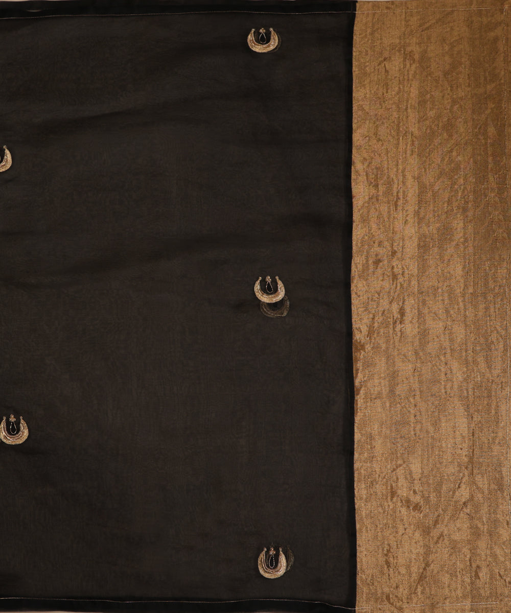 Black silk organza dupatta draped over a wooden chair, featuring crescent-shaped zardozi bootis and a contrasting gold tissue palla.