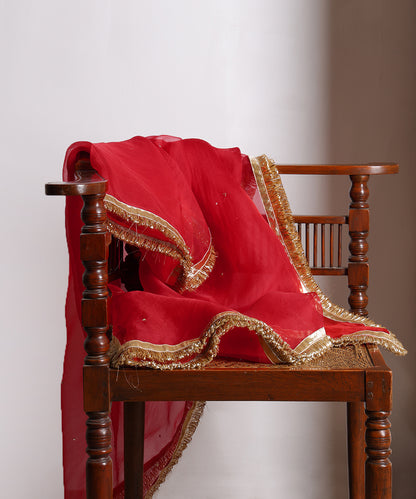 Close-up of red silk organza dupatta with hand-embroidered sequins, metallic gota lampi border and gold kiran finishing.